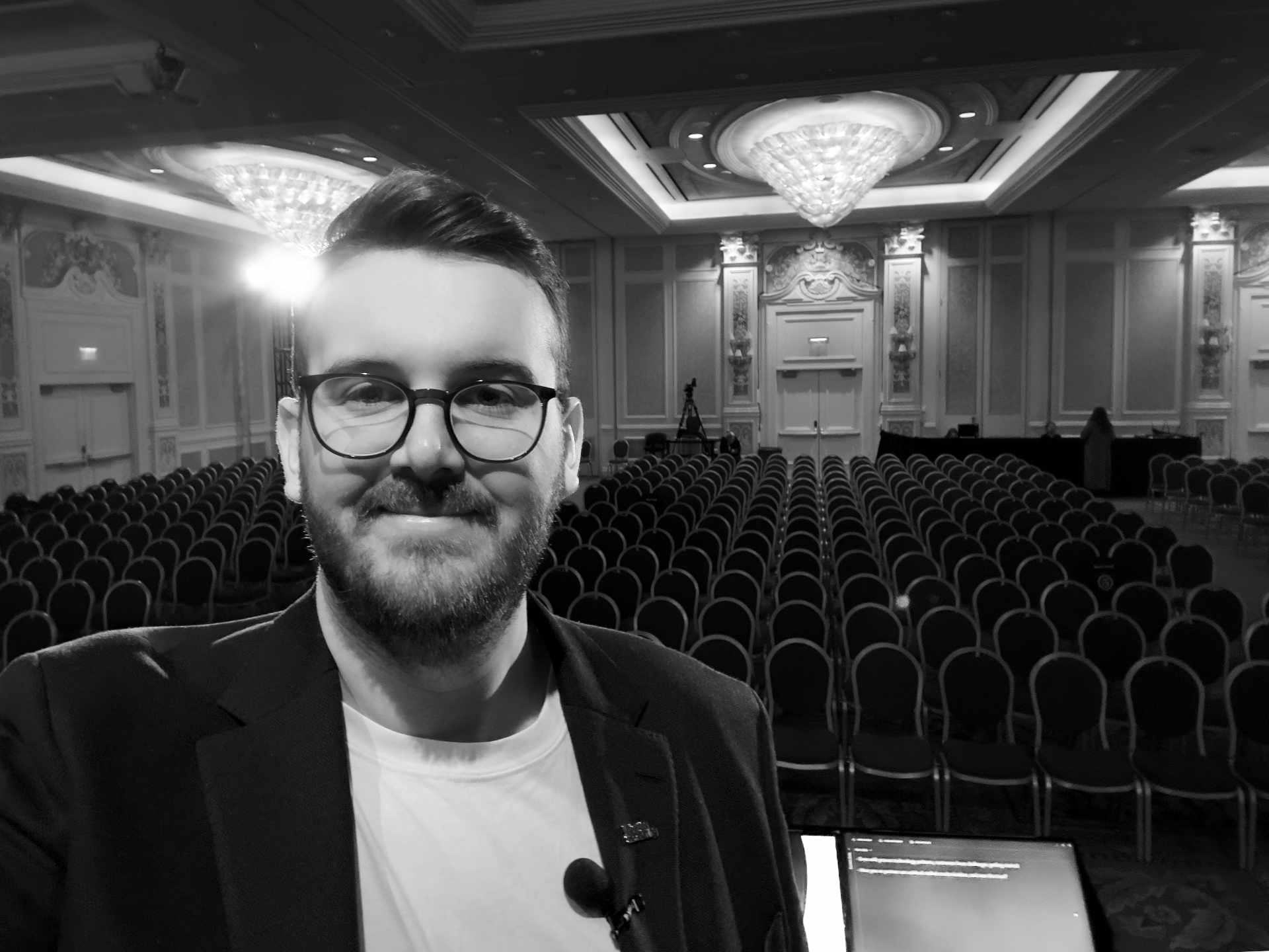 A person standing on stage in a conference room.